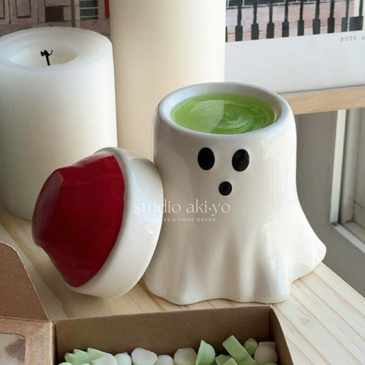 Ceramic ghost-shaped mug with green liquid on a wooden surface, featuring 'studio akiyo' branding.