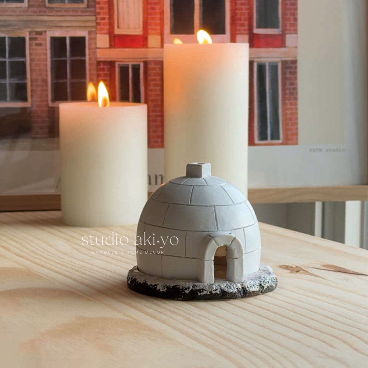 Small dome-shaped object on a wooden surface with candles in the background