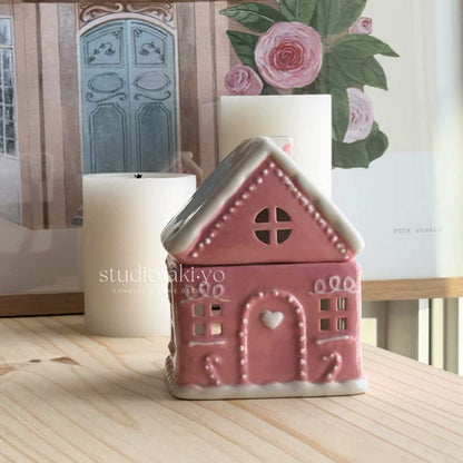 Pink ceramic gingerbread house wax melt burner, perfect for the holiday season.