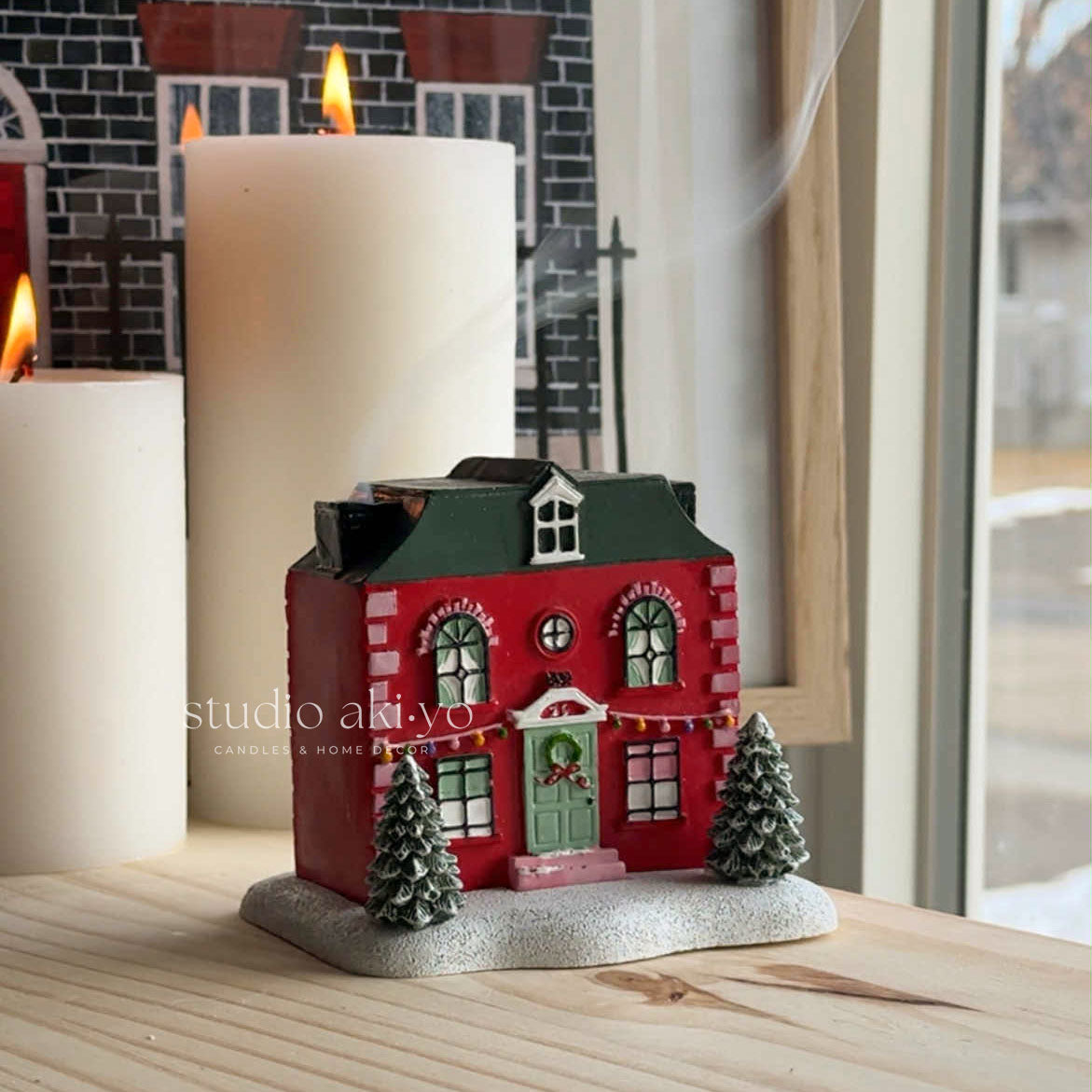 Red Holiday House Incense Cone Holder a stack of books with decorative elements.