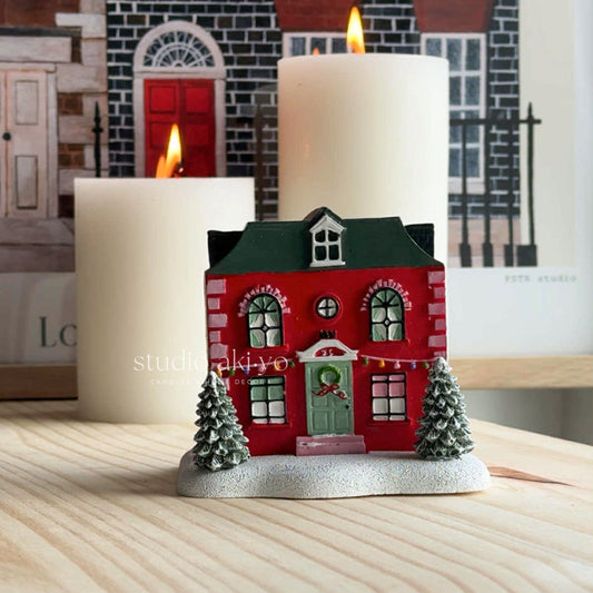 Red Holiday House Incense Cone Holder a stack of books with decorative elements.
