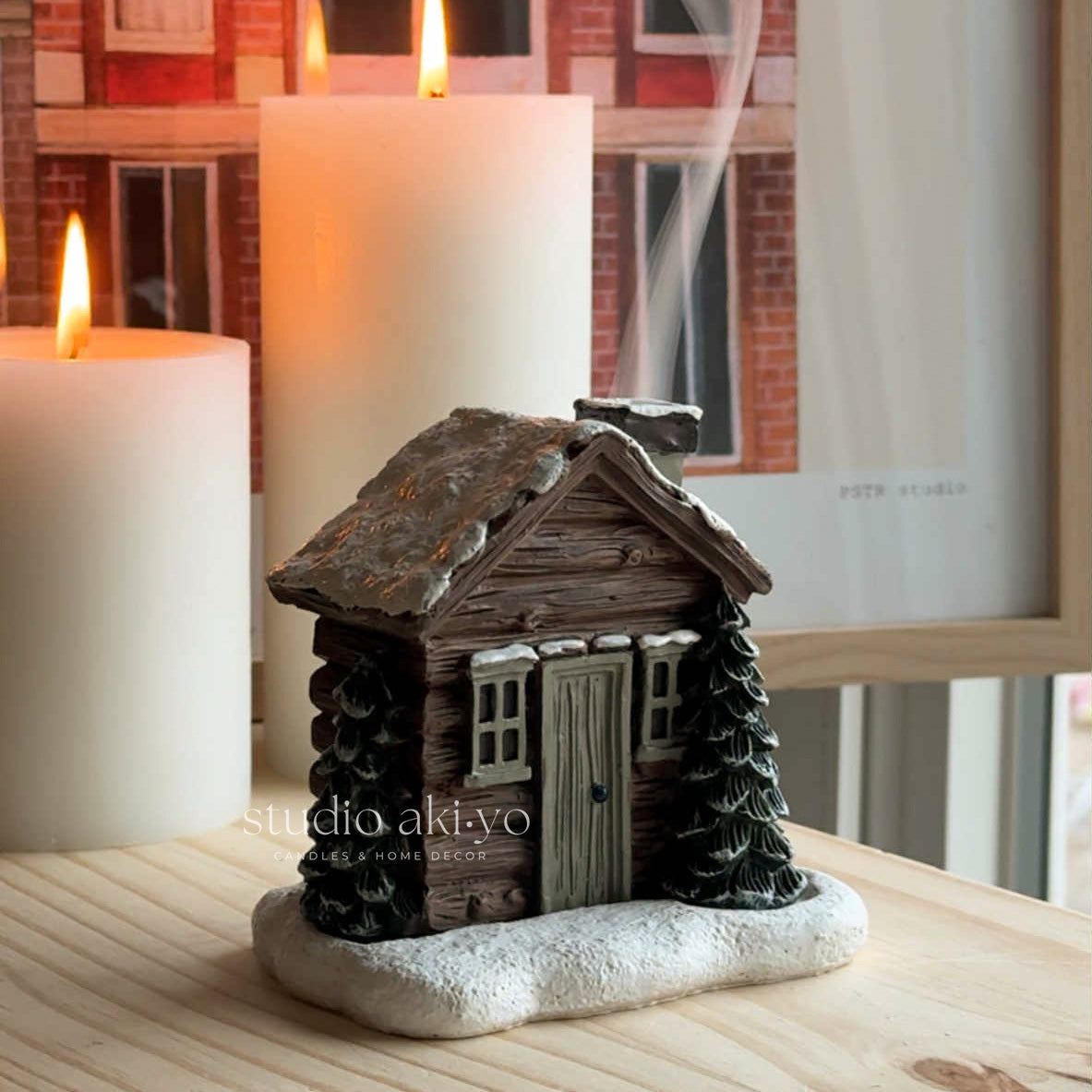 Winter Log cabin incense cone holder on top of books with a soft background