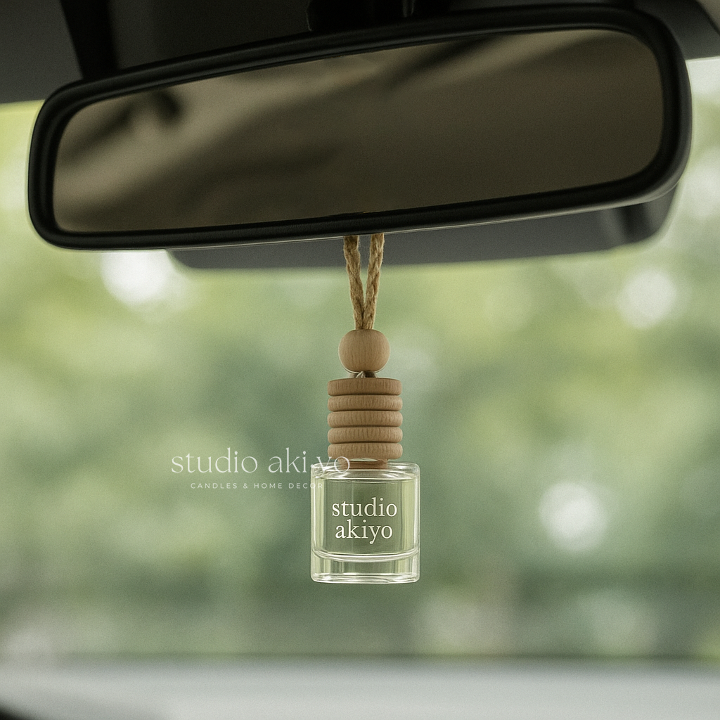 Car air freshener with 'studio akiyo' branding hanging from a car's rearview mirror.