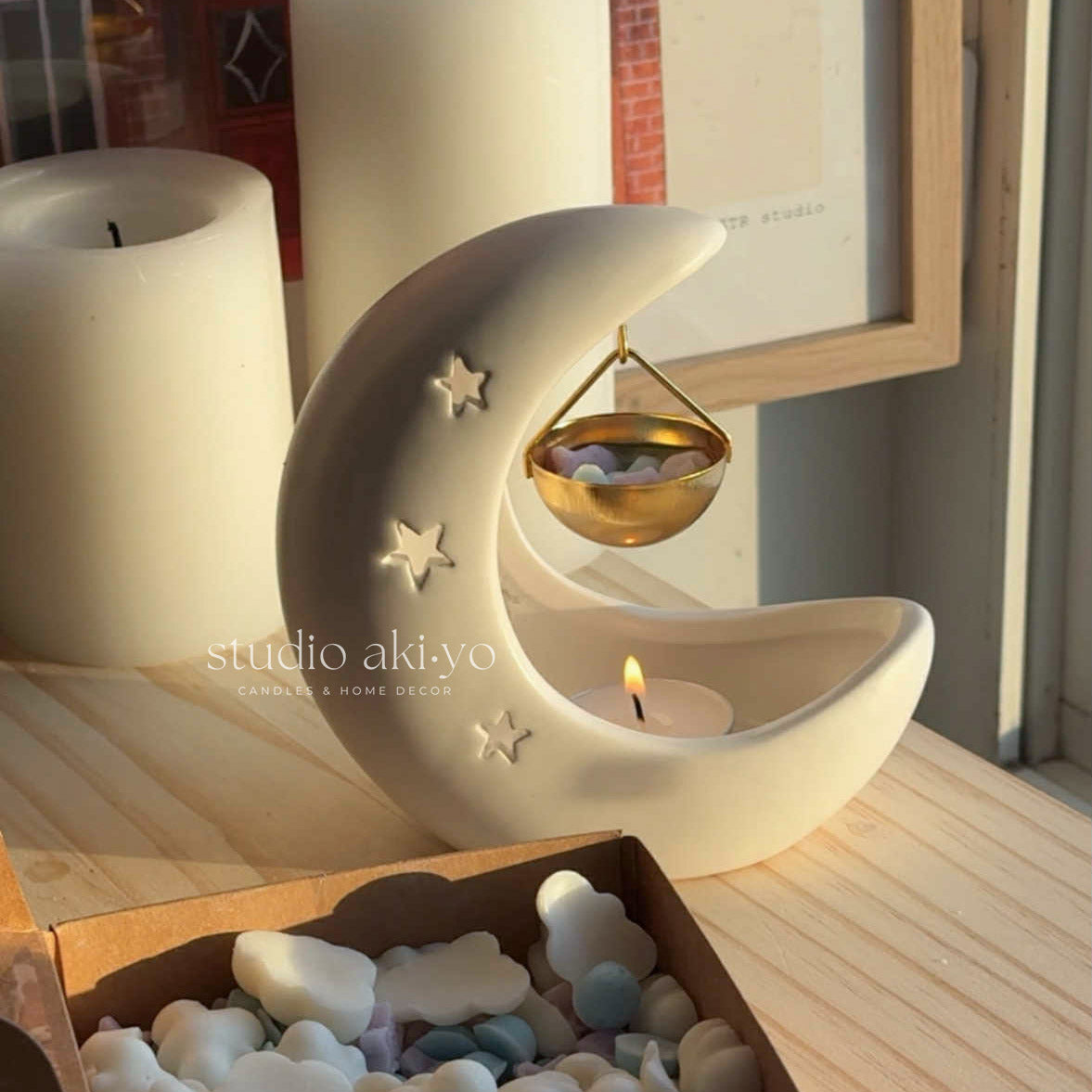 White gold crescent moon burner with Studio Akiyo branding.